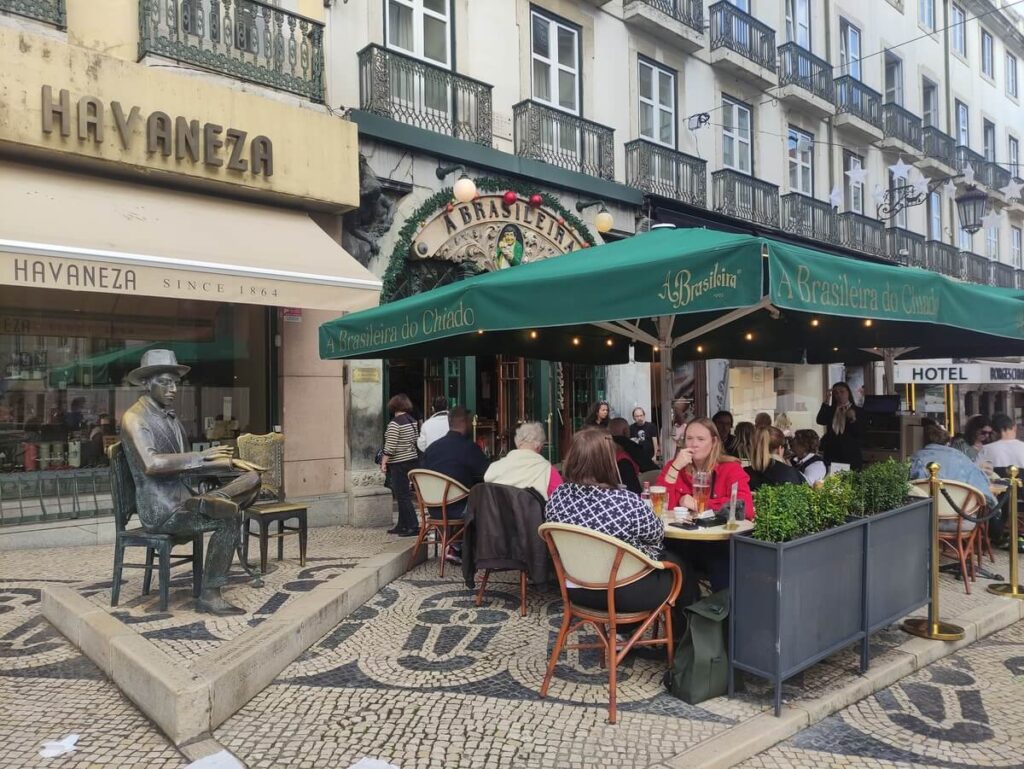 La statua di Fernando Pessoa accanto ai tavolini del bar A Brasileira